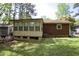 The back of the house features a cozy enclosed porch and a well-maintained lawn, perfect for outdoor activities at 2726 Thelma St, Durham, NC 27704