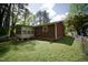 View of the back of the house, including the enclosed porch, the air conditioning unit, and the surrounding yard at 2726 Thelma St, Durham, NC 27704