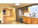 Open-concept kitchen with stainless steel refrigerator, wooden cabinets, and modern sink at 2726 Thelma St, Durham, NC 27704