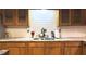 Close-up of kitchen sink with marble countertops and wooden cabinets, perfect for cooking at 2726 Thelma St, Durham, NC 27704
