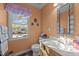 A cozy bathroom with peach walls, decorative mirror, and ornate decorations at 300 Pate St, Apex, NC 27502