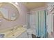 Compact bathroom with blue sea-themed shower curtain, gold accents and tan countertops at 300 Pate St, Apex, NC 27502