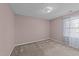A simple bedroom with pink walls, carpeted floors, and a window that allows natural light at 300 Pate St, Apex, NC 27502