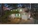 Charming home at dusk featuring green shutters, a front porch, a well-kept lawn, and an attached one-car garage at 300 Pate St, Apex, NC 27502
