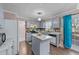 A traditionally styled kitchen features gray cabinets, a center island, a view to the backyard, and access to dining at 300 Pate St, Apex, NC 27502