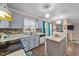 A traditionally styled kitchen features gray cabinets, stainless steel appliances, and a pass-through to the living room at 300 Pate St, Apex, NC 27502