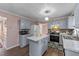 A traditionally styled kitchen features gray cabinets, a center island, and stainless steel appliances at 300 Pate St, Apex, NC 27502