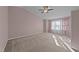 Bright main bedroom with a ceiling fan, large window, and plush carpeting at 300 Pate St, Apex, NC 27502