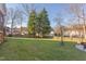 Spacious backyard with mature trees, green grass, and a charming wooden fence at 3109 Doe Hill Ct, Raleigh, NC 27612