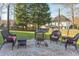 Backyard patio featuring a fire pit with black wicker chairs and mature trees at 3109 Doe Hill Ct, Raleigh, NC 27612