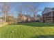 Large backyard with a fire pit area, surrounded by mature trees and a wooden fence at 3109 Doe Hill Ct, Raleigh, NC 27612