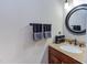 Bathroom featuring a wood vanity with granite countertop and round mirror at 3109 Doe Hill Ct, Raleigh, NC 27612