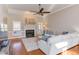 Bright living room with fireplace, hardwood floors, ceiling fan, and a comfortable sectional sofa at 3109 Doe Hill Ct, Raleigh, NC 27612