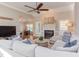 Bright living room with fireplace, hardwood floors, ceiling fan, and a comfortable sectional sofa at 3109 Doe Hill Ct, Raleigh, NC 27612