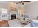 Bright living room with fireplace, hardwood floors, ceiling fan, and a comfortable sectional sofa at 3109 Doe Hill Ct, Raleigh, NC 27612