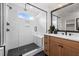 Modern bathroom with frameless glass shower, black hardware, subway tiles, and wood vanity at 353 Belmont Stakes Ln, Wendell, NC 27591