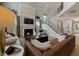 Cozy living room featuring a fireplace, a large sofa, and an open staircase at 353 Belmont Stakes Ln, Wendell, NC 27591