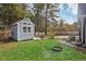 Charming backyard shed with window, set on a grassy lawn, provides perfect extra storage and style at 3746 Guess Rd, Durham, NC 27705