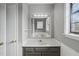 Bathroom featuring a white vanity, decorative mirror, and ample natural light from the window at 3746 Guess Rd, Durham, NC 27705