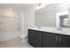 Clean bathroom featuring a double vanity with dark cabinets, a large mirror, and a tub with shower at 3933 Willow Gate Way, Knightdale, NC 27604