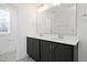 Bathroom featuring a double vanity with dark cabinets, a large mirror, and a patterned tile floor at 3933 Willow Gate Way, Knightdale, NC 27604