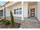 Inviting front porch with brick accents and a dark wood door at 3933 Willow Gate Way, Knightdale, NC 27604