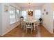 Sunlit dining area with classic chandelier, large windows, and seating for four at 4212 Birmingham Way, Raleigh, NC 27604