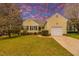 Charming yellow home featuring black shutters, a manicured lawn, and an attached one car garage at 4212 Birmingham Way, Raleigh, NC 27604