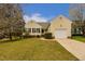 Charming yellow home featuring black shutters, a manicured lawn, and an attached one car garage at 4212 Birmingham Way, Raleigh, NC 27604