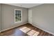 This bedroom features wood-look floors, a light grey paint, and a large double hung window at 4804 Red Coat Ct, Raleigh, NC 27616