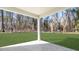 A backyard view from under a porch with a well manicured lawn extending to a tree line at 4879 Pioneer Dr, Sanford, NC 27330