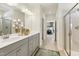 Modern bathroom featuring double vanity with gray cabinets and glass shower, adjacent to Primary bedroom at 4879 Pioneer Dr, Sanford, NC 27330