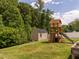 Spacious backyard featuring a shed and a charming playhouse with slide and climbing rungs at 516 Spaulding St, Burlington, NC 27215