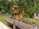 A backyard wooden playset and raised garden beds are located in this fenced yard at 516 Spaulding St, Burlington, NC 27215