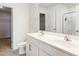Bright bathroom featuring double sinks with white cabinets, toilet, and door to walk-in closet at 516 Spaulding St, Burlington, NC 27215
