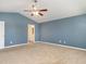 Spacious bedroom with blue walls, ceiling fan, neutral carpet, and doorway to the bathroom at 516 Spaulding St, Burlington, NC 27215
