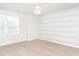 Bedroom with neutral carpet, white and gray striped accent wall, window, and ceiling fan at 516 Spaulding St, Burlington, NC 27215