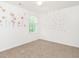 Bedroom with neutral carpet, white walls with decals, window, and ceiling fan at 516 Spaulding St, Burlington, NC 27215