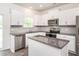 Modern kitchen with white cabinets, stainless steel appliances, granite countertops, and a kitchen island at 516 Spaulding St, Burlington, NC 27215
