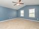Large main bedroom with ceiling fan, two windows providing natural light, and blue walls at 516 Spaulding St, Burlington, NC 27215