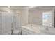 Modern bathroom featuring a glass shower enclosure, double vanity, and neutral color palette at 521 Fife Ct, Gibsonville, NC 27249