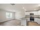 Bright, open-concept kitchen featuring white cabinets, stainless steel appliances, and modern flooring at 521 Fife Ct, Gibsonville, NC 27249