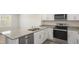 Close-up of a well-equipped kitchen with granite countertops, stainless steel appliances, and white cabinetry at 521 Fife Ct, Gibsonville, NC 27249