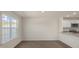 Sun-drenched living room with wood-look floors adjacent to kitchen featuring stainless appliances at 521 Fife Ct, Gibsonville, NC 27249