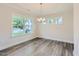 Elegant dining room featuring hardwood floors, a modern chandelier, and large windows for natural light at 624 Emerald Bay Cir, Raleigh, NC 27610