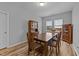 Well-lit dining room with wood table set and matching hardwood floors and cabinets at 629 Kenyon Spring Dr, Zebulon, NC 27597