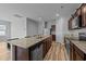 Modern kitchen boasts an island with sink, granite countertops, and stainless-steel appliances at 629 Kenyon Spring Dr, Zebulon, NC 27597