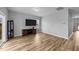 Open-plan living room with hardwood floors, TV, and natural light from the window at 629 Kenyon Spring Dr, Zebulon, NC 27597