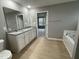 Bathroom with double sink vanity, granite counters, soaking tub, and doorway to the bedroom at 76 Mangrove Ct, Four Oaks, NC 27524