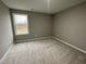 Bedroom features neutral carpet, gray walls, and a sun-filled window overlooking the property at 76 Mangrove Ct, Four Oaks, NC 27524